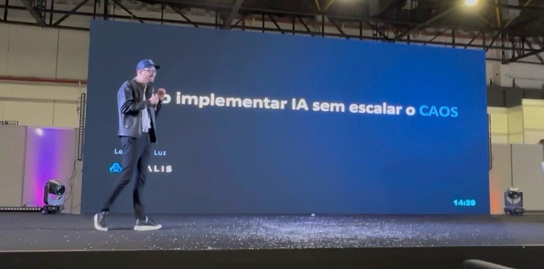 Leonardo Luz no palco, diante do slide da palestra Como implementar IA sem escalar o caos.